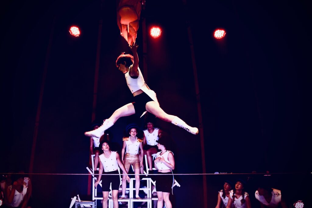 Artiste de la Compagnie Cirque-en-Ciel en plein saut acrobatique lors du spectacle